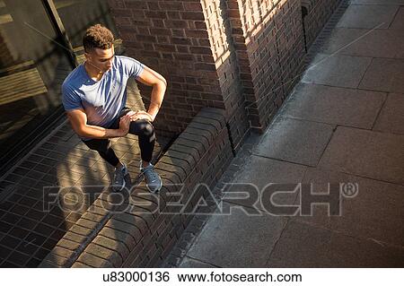 Stock Photograph - Man stretching beside column. Fotosearch