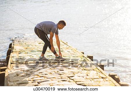 Man stretching on pier, Wapping, London, UK View Large Photo Image Stock Photo - Man stretching on pier, Wapping, London, UK. Fotosearch
