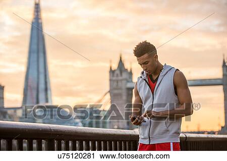 Man using mobile phone by riverside, Tower Bridge and The Shard in background, Wapping, London, UK View Large Photo Image Stock Image - Man using mobile phone by riverside, Tower Bridge and The Shard in background, Wapping, London, UK. Fotosearch