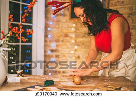 Mature woman rolling Christmas cookie pastry at kitchen counter View Large Photo Image Stock Image - Mature woman rolling Christmas cookie pastry at kitchen counter. Fotosearch