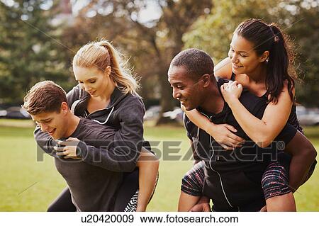 Men and women having fun training in park, having piggy back race View Large Photo Image Stock Photo - Men and women having fun training in park, having piggy back race. Fotosearch