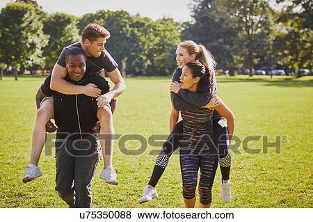 Men and women having fun training in park, having piggy back race View Large Photo Image Stock Photo - Men and women having fun training in park, having piggy back race. Fotosearch