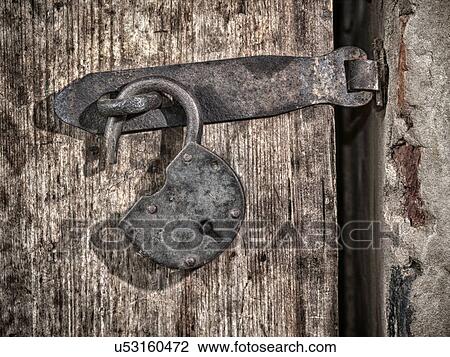 Stock Image - Metal padlock on wooden door. Fotosearch