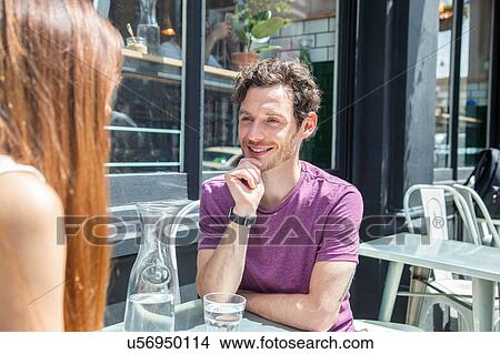 Mid adult couple chatting at city sidewalk cafe View Large Photo Image Picture - Mid adult couple chatting at city sidewalk cafe. Fotosearch
