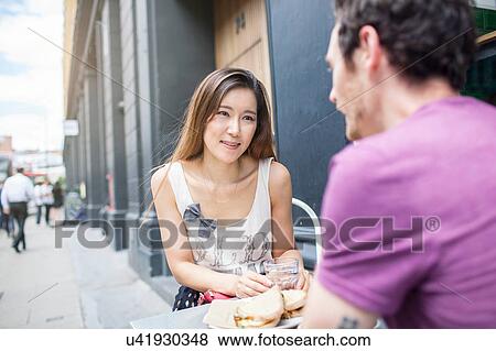 Mid adult couple having lunch at city sidewalk cafe View Large Photo Image Stock Photo - Mid adult couple having lunch at city sidewalk cafe. Fotosearch