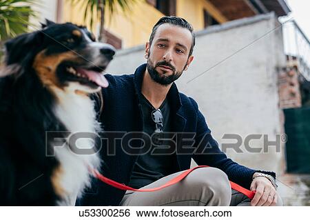 Mid adult man sitting with dog on city step View Large Photo Image Stock Photograph - Mid adult man sitting with dog on city step. Fotosearch