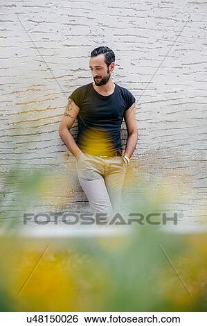 Mid adult man with hands in pockets leaning against wall View Large Photo Image Stock Photograph - Mid adult man with hands in pockets leaning against wall. Fotosearch