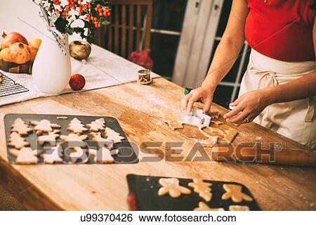 Mid section of woman cutting Christmas cookie shapes at kitchen counter View Large Photo Image Stock Photograph - Mid section of woman cutting Christmas cookie shapes at kitchen counter. Fotosearch