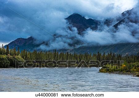 Stock Image - Mountain, river and clouds view in Autumn, off Richardson Highway, Route 4, North of Paxon, Alaska. Fotosearch