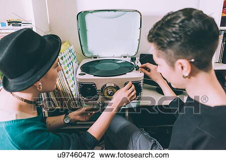 Over shoulder view of two young women playing vinyl on vintage turntable View Large Photo Image Stock Image - Over shoulder view of two young women playing vinyl on vintage turntable. Fotosearch