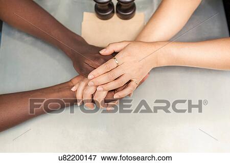 Overhead view of couple holding hands at sidewalk cafe table View Large Photo Image Stock Photo - Overhead view of couple holding hands at sidewalk cafe table. Fotosearch
