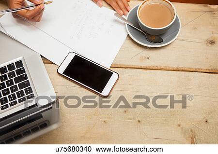 Overhead view of female hands doing paperwork at cafe table View Large Photo Image Stock Image - Overhead view of female hands doing paperwork at cafe table. Fotosearch