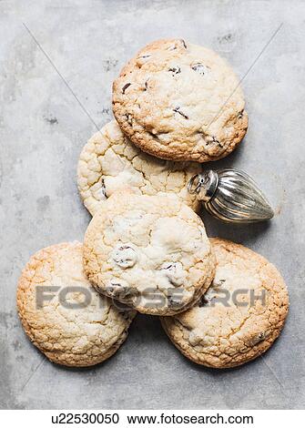 Stock Image - Overhead view of fresh cookies and Christmas bauble. Fotosearch