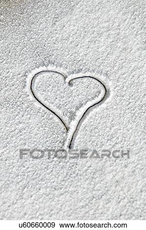 Stock Photo - Overhead view of heart shape drawn in white icing sugar. Fotosearch