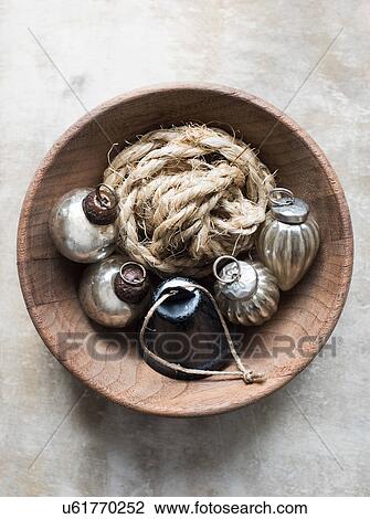 Stock Image - Overhead view of silver Christmas baubles and string in bowl. Fotosearch