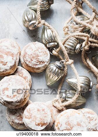 Stock Photo - Overhead view of silver Christmas baubles and fresh scones. Fotosearch