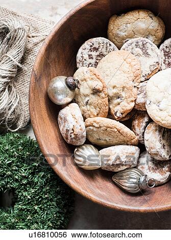 Stock Photograph - Overhead view of silver Christmas baubles and fresh cookies in bowl. Fotosearch