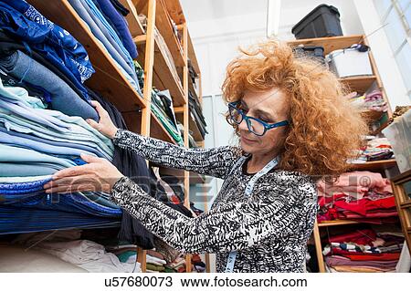 Owner of small fashion business working in material storeroom View Large Photo Image Stock Image - Owner of small fashion business working in material storeroom. Fotosearch