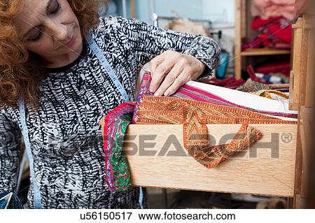 Owner of small fashion business working in material storeroom View Large Photo Image Stock Photo - Owner of small fashion business working in material storeroom. Fotosearch