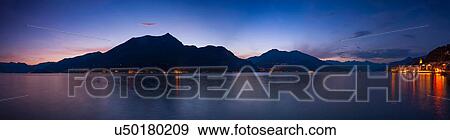Panoramic view of silhouetted mountains over Lake Como at night, Bellagio, Italy View Large Photo Image Stock Photo - Panoramic view of silhouetted mountains over Lake Como at night, Bellagio, Italy. Fotosearch