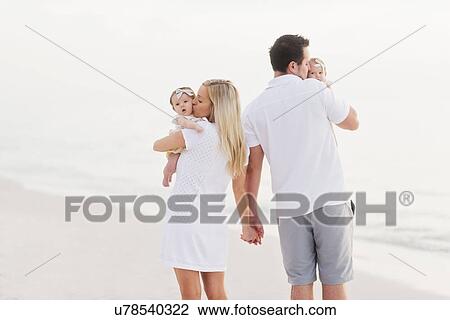 Parents walking with babies (2-5 months) along seashore View Large Photo Image Stock Image - Parents walking with babies (2-5 months) along seashore. Fotosearch