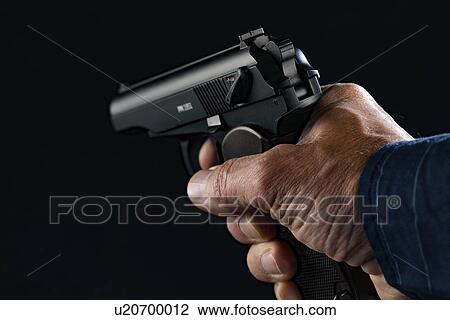 Stock Image - Person holding handgun. Fotosearch