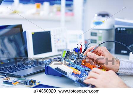 Stock Image - Person repairing electronic equipment. Fotosearch