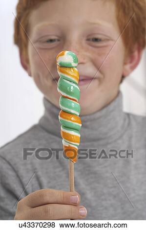 Portrait of a boy holding lollipop View Large Photo Image Stock Photo - Portrait of a boy holding lollipop. Fotosearch