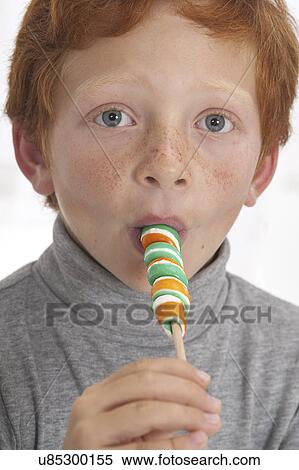Stock Photography - Portrait of a boy sucking lollipop. Fotosearch