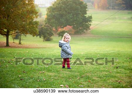 Portrait of female toddler looking over her shoulder in autumn park View Large Photo Image Stock Photo - Portrait of female toddler looking over her shoulder in autumn park. Fotosearch