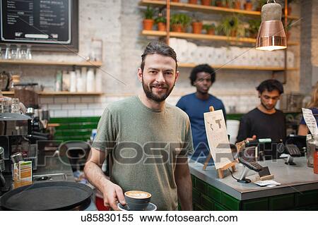 Portrait of male barista serving coffee in cafe View Large Photo Image Stock Photography - Portrait of male barista serving coffee in cafe. Fotosearch