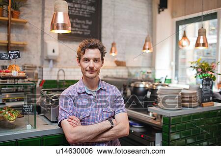 Stock Photograph - Portrait of mid adult man in cafe. Fotosearch