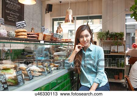 Stock Image - Portrait of mid adult woman in cafe. Fotosearch