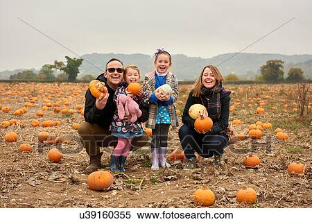 Portrait of parents and two daughters crouching in pumpkin field View Large Photo Image Stock Photography - Portrait of parents and two daughters crouching in pumpkin field. Fotosearch