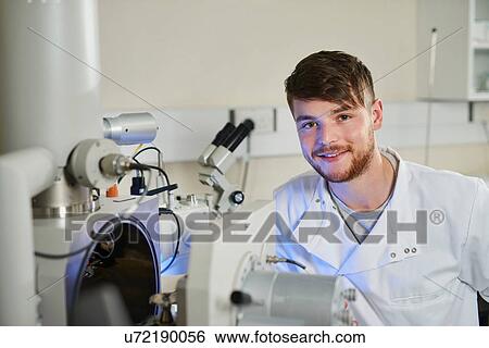 Stock Photograph - Portrait of scientists in laboratory looking at camera smiling. Fotosearch