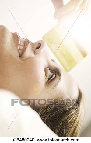 Portrait of smiling mid adult woman lying down and looking at credit card View Large Photo Image Stock Image - Portrait of smiling mid adult woman lying down and looking at credit card. Fotosearch
