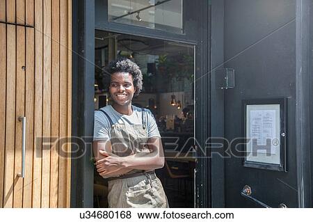 Stock Photo - Portrait of waiter in doorway of city sidewalk cafe. Fotosearch