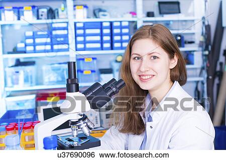 Stock Photograph - Portrait of woman with microscope. Fotosearch