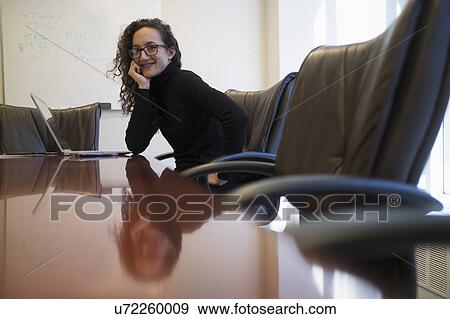 Portrait of young business woman sitting in conference room with laptop View Large Photo Image Stock Photo - Portrait of young business woman sitting in conference room with laptop. Fotosearch