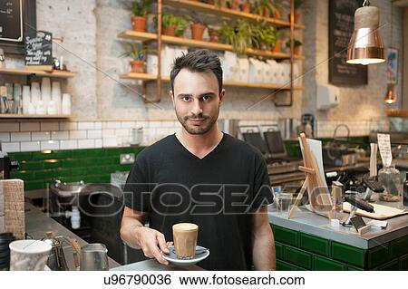 Portrait of young male barista serving glass of coffee in cafe View Large Photo Image Stock Photograph - Portrait of young male barista serving glass of coffee in cafe. Fotosearch