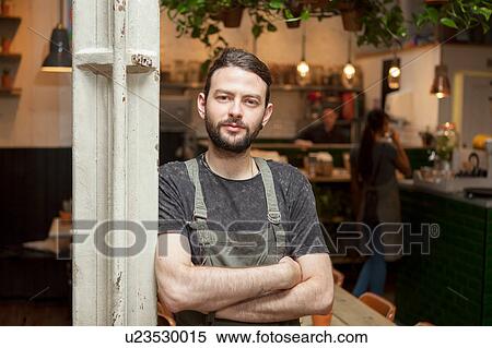 Stock Photography - Portrait of young male cafe owner in cafe. Fotosearch