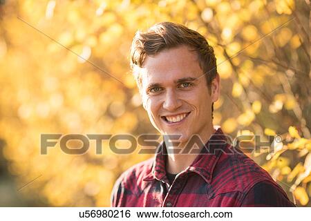 Portrait of young man outdoors, in rural setting View Large Photo Image Stock Photograph - Portrait of young man outdoors, in rural setting. Fotosearch
