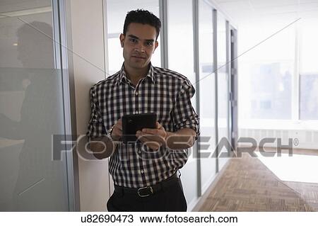 Stock Image - Portrait of young man with digital tablet. Fotosearch