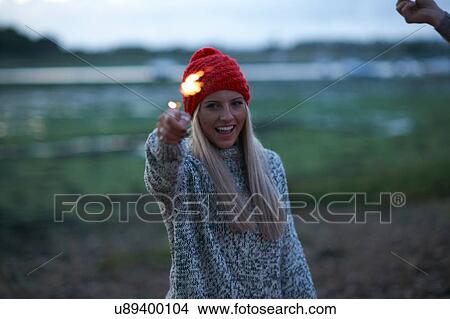 Portrait of young woman playing with sparklers near sea at dusk View Large Photo Image Picture - Portrait of young woman playing with sparklers near sea at dusk. Fotosearch
