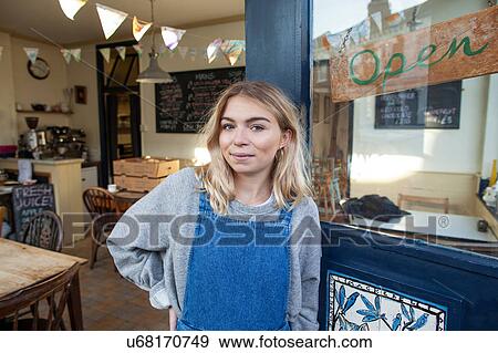 Portrait of young woman standing in doorway of cafe View Large Photo Image Stock Photo - Portrait of young woman standing in doorway of cafe. Fotosearch