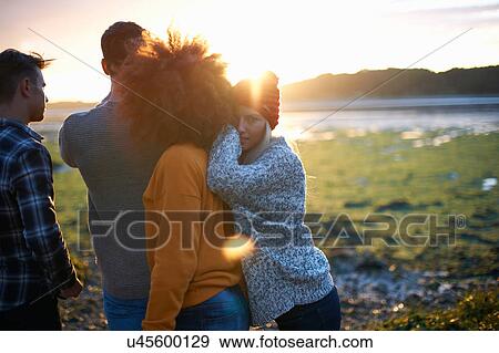Portrait of young woman with adult friends watching sunset over sea View Large Photo Image Stock Photo - Portrait of young woman with adult friends watching sunset over sea. Fotosearch
