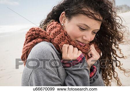 Stock Photo - Portrait of young woman wrapped in scarf on windy beach, Western Cape, South Africa. Fotosearch