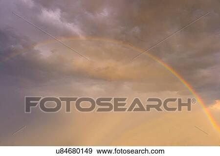 Rainbow against clouds in sunlight View Large Photo Image Stock Photo - Rainbow against clouds in sunlight. Fotosearch