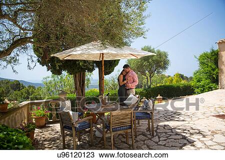 Stock Image - Romantic couple on patio at boutique hotel, Majorca, Spain. Fotosearch