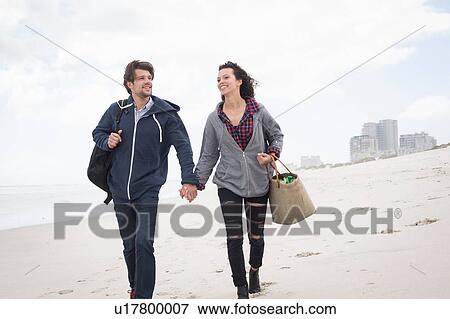 Romantic young couple strolling on windswept beach, Western Cape, South Africa View Large Photo Image Stock Photo - Romantic young couple strolling on windswept beach, Western Cape, South Africa. Fotosearch